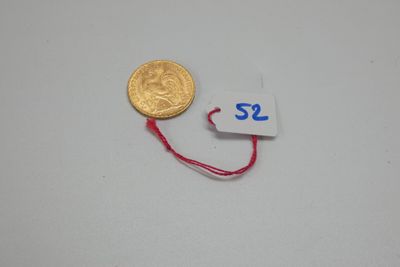 un gros plan d'une pièce d'or à laquelle est attaché un fil rouge