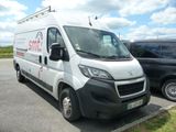 une camionnette blanche garée sur un parking à côté d'une voiture noire