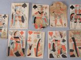 several old playing cards are arranged in a row on a table