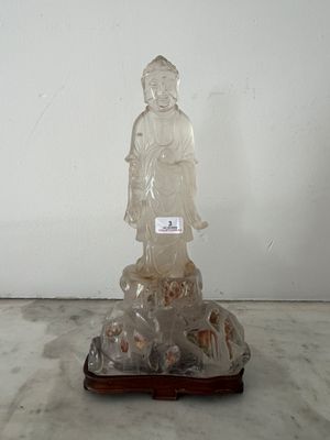 une statue représentant une personne assise sur un rocher