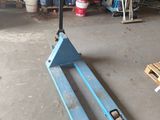 a blue forklift sitting in a garage next to a pallet