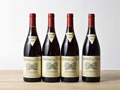 quatre bouteilles de vin sont posées sur une table en bois