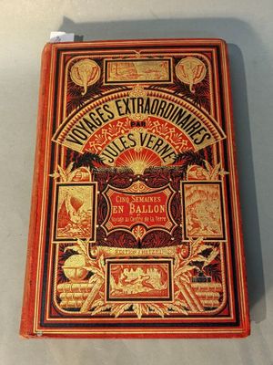 an old book on a table with a red cover