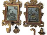 two framed pictures of a man and a woman on a wall with a pipe