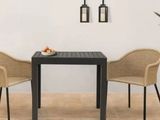 two chairs and a table with a bowl of fruit on it