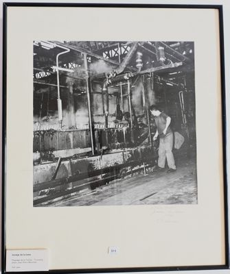 photographie en noir et blanc d'un homme travaillant sur une machine dans une usine