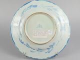 underside view of a blue and white plate with a bird on it