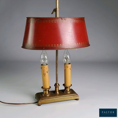une lampe posée sur une table, avec un abat-jour rouge