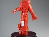 an orange statue of a woman holding a child on a wooden stand