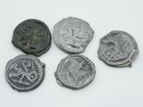 quatre pièces de monnaie anciennes sont disposées en rangée sur une surface blanche