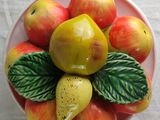 a bowl of apples and pears on a table