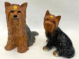 deux figurines de chiens assis l'une à côté de l'autre