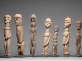 a group of five carved wooden figures sitting on top of a table