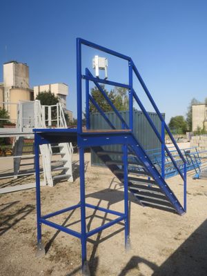 un escalier métallique bleu menant au sommet d'un immeuble