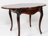 une table à manger ovale avec un plateau en marbre et des pieds sculptés