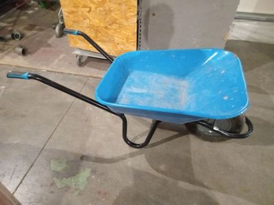 a blue wheelbarrow that is sitting on the floor