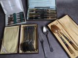 une boîte contenant de nombreux types de cuillères et de fourchettes
