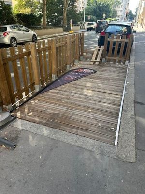 une clôture abîmée au bord de la rue