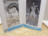 two framed pictures of batman and superman are on display in a box