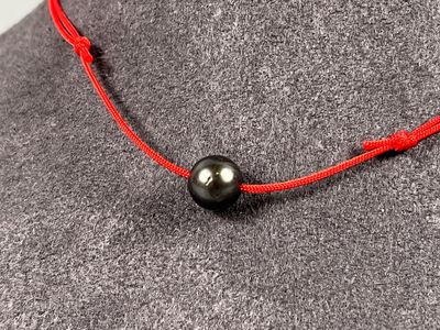 Collier composé d'un cordon en nylon rouge à noeuds coulissa…