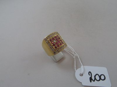 a gold ring with red and white stones on it