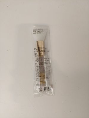 un gros plan d'un tube de dentifrice posé sur une surface blanche