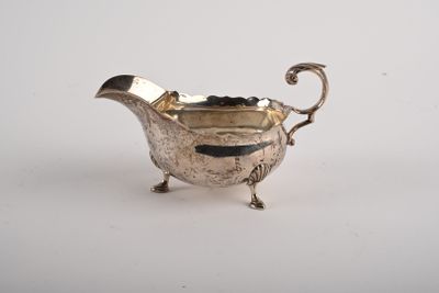 une saucière ancienne en métal argenté, munie d'une poignée et de pieds