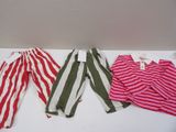 three pairs of striped pants are lined up on a white table