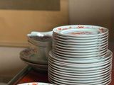 a stack of plates on a table with a picture on the wall in the background