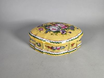 une boîte jaune décorée de fleurs, posée sur une table