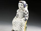 une figurine représentant une femme assise sur un rocher