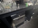 a counter with a bunch of empty glasses on it