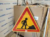 a sign that is on the ground next to a pile of boxes