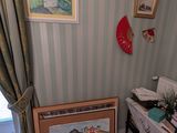 une photo d'un salon avec un piano et un tableau accroché au mur