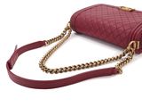 burgundy quilted purse with gold chain strap on a white background