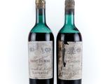 two bottles of wine sitting next to each other on a white surface