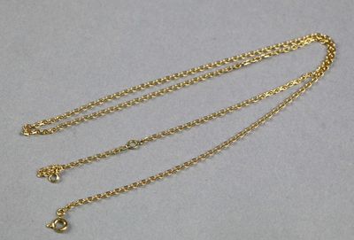 gros plan d'un collier en or auquel est attachée une chaîne