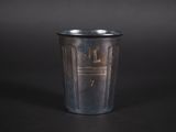 une vieille tasse en métal posée sur une table noire