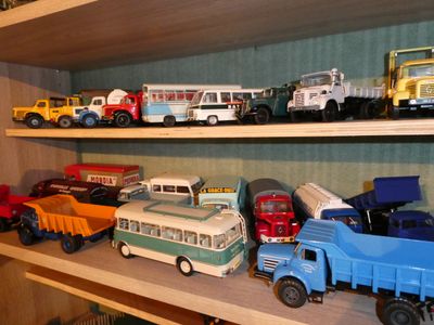 many toy trucks on a shelf in a room