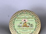 two small tins of perfume sitting next to each other on a table