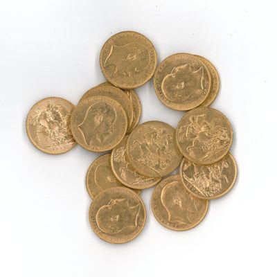 quelques pièces d'or posées sur une surface blanche, sur fond blanc
