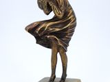 statue en bronze représentant une femme tenant une boule, posée sur un socle en marbre