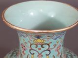 a blue vase with a gold rim sitting on a table