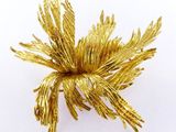 une image représentant une broche en forme de fleur dorée sur fond blanc