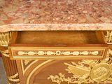a marble top desk with a gold decoration on it
