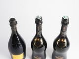 three bottles of champagne sitting next to each other on a white surface