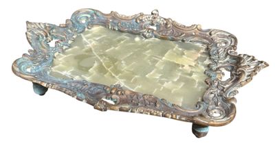 a silver tray with a green glass in it