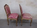 pair of pink upholstered chairs against a white wall