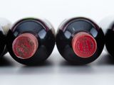 three bottles of wine are lined up in a row on a white surface