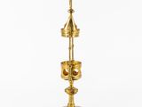 a gold plated metal bell with a rope hanging from it ' s neck